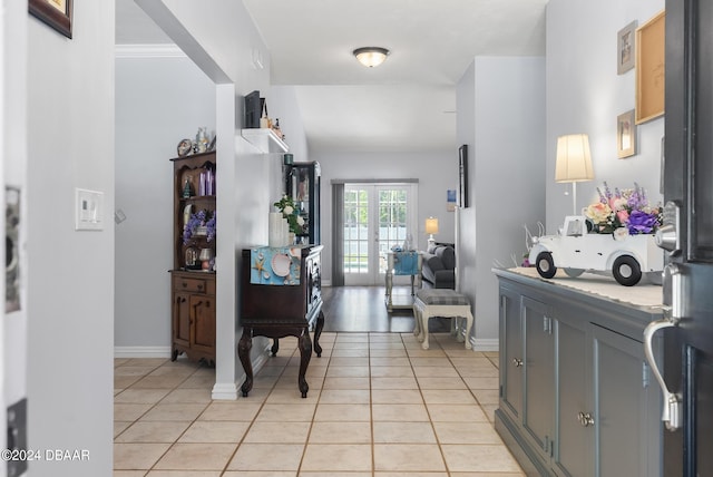 foyer entrance with french doors, light tile patterned flooring, and baseboards