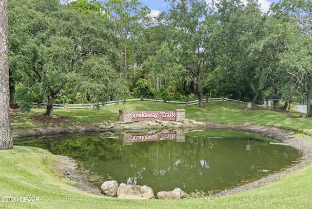 view of community featuring a water view and a yard