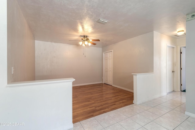 tiled spare room with ceiling fan and a textured ceiling