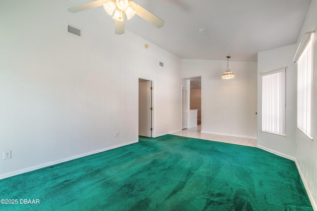 empty room featuring vaulted ceiling, light carpet, and ceiling fan