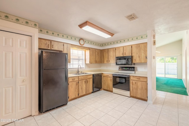 kitchen with sink, light tile patterned floors, and black appliances