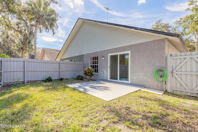 back of house with a lawn and a patio area