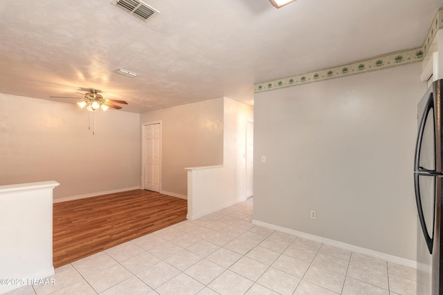 tiled spare room with a textured ceiling and ceiling fan