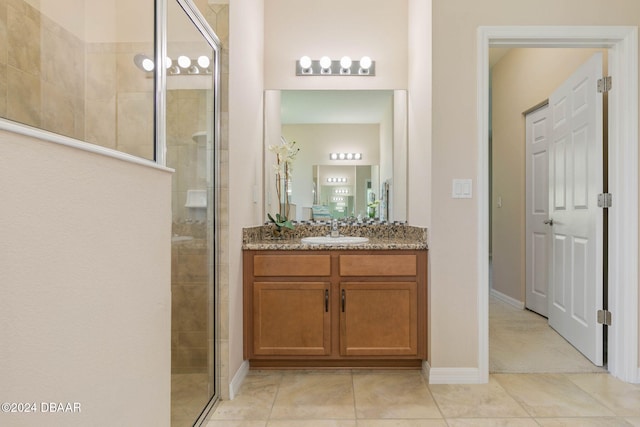 bathroom featuring tile patterned floors, vanity, and a shower with shower door