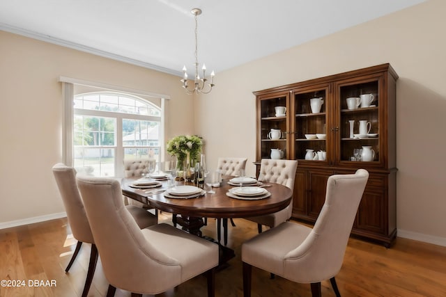 dining room with light hardwood / wood-style floors and an inviting chandelier