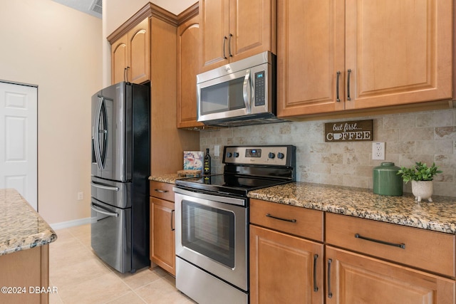 kitchen with tasteful backsplash, light stone countertops, light tile patterned floors, and stainless steel appliances