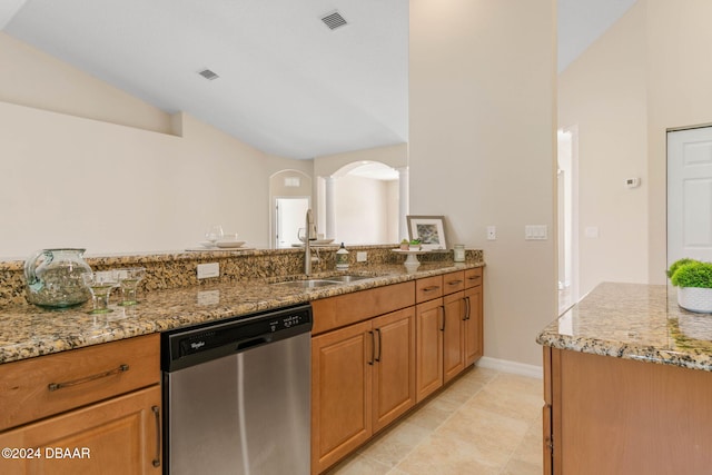 kitchen with light stone countertops, sink, stainless steel dishwasher, and vaulted ceiling