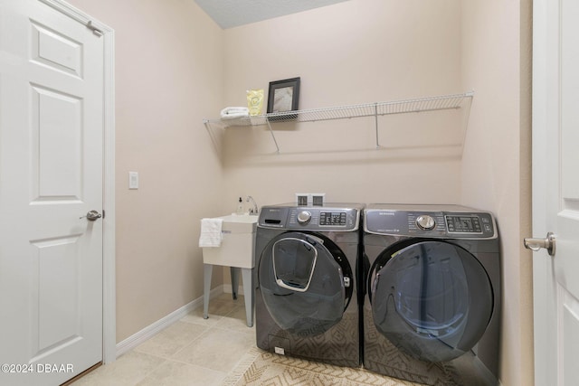 clothes washing area featuring light tile patterned floors and independent washer and dryer