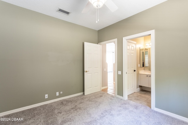 unfurnished bedroom with connected bathroom, ceiling fan, and light colored carpet