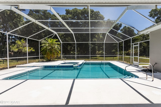 view of pool with an in ground hot tub, glass enclosure, and a patio area