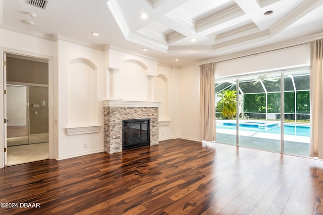 unfurnished living room with beam ceiling, dark wood-type flooring, coffered ceiling, crown molding, and a fireplace