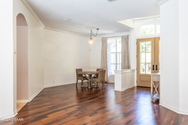 dining room featuring a textured ceiling, dark hardwood / wood-style flooring, and ornamental molding