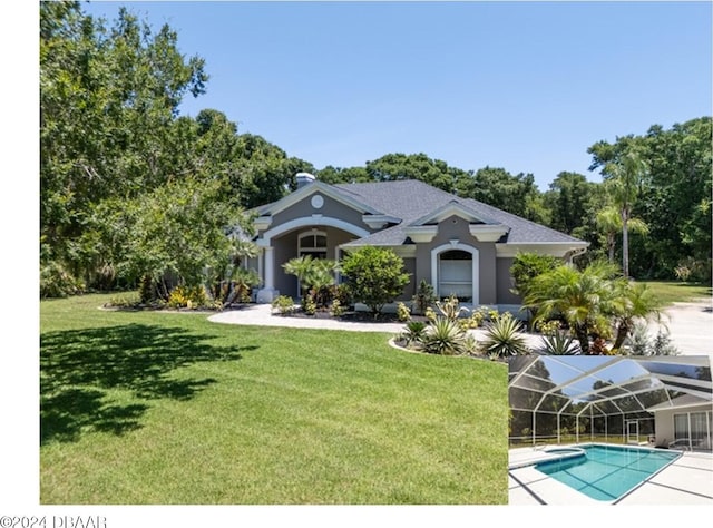 rear view of house with a lawn and a lanai