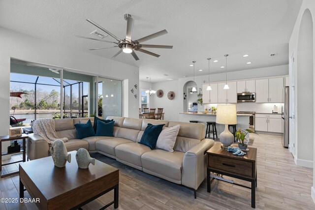 kitchen featuring decorative light fixtures, appliances with stainless steel finishes, sink, and a center island with sink