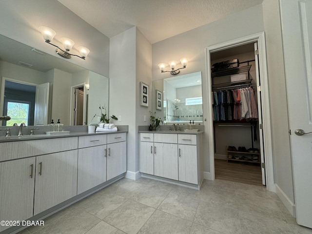 bathroom featuring a textured ceiling, tile patterned flooring, and vanity