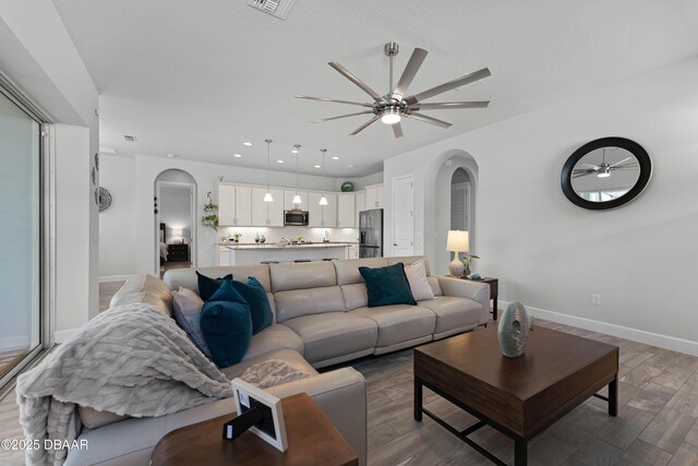 living room featuring ceiling fan and a textured ceiling