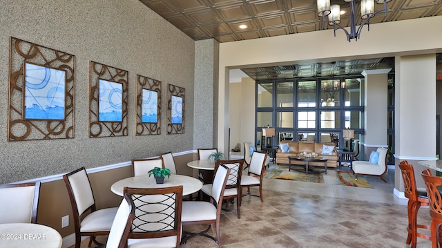 dining room with wallpapered walls, an ornate ceiling, a wainscoted wall, and an inviting chandelier