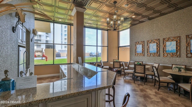 interior space featuring wallpapered walls, dark stone countertops, an ornate ceiling, and a notable chandelier