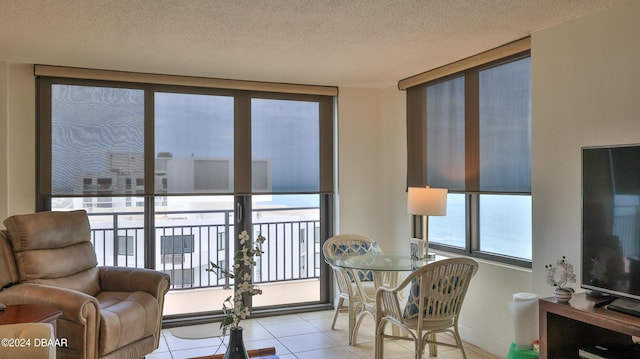 interior space with expansive windows, a textured ceiling, tile patterned flooring, and baseboards