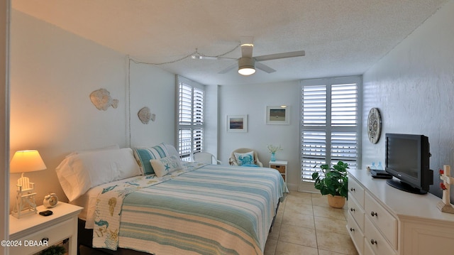 bedroom featuring light tile patterned floors, ceiling fan, multiple windows, and a textured ceiling