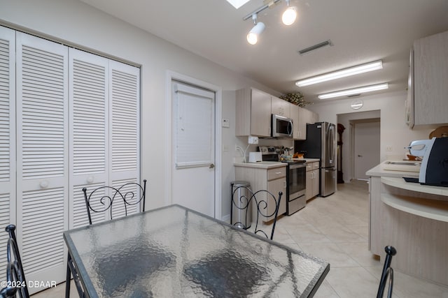 kitchen with sink, light tile patterned flooring, and stainless steel appliances