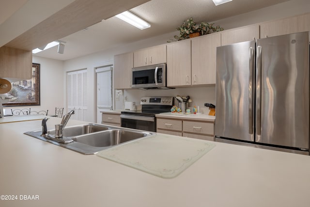 kitchen with light brown cabinets, sink, and stainless steel appliances