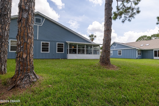 rear view of house with a sunroom and a lawn