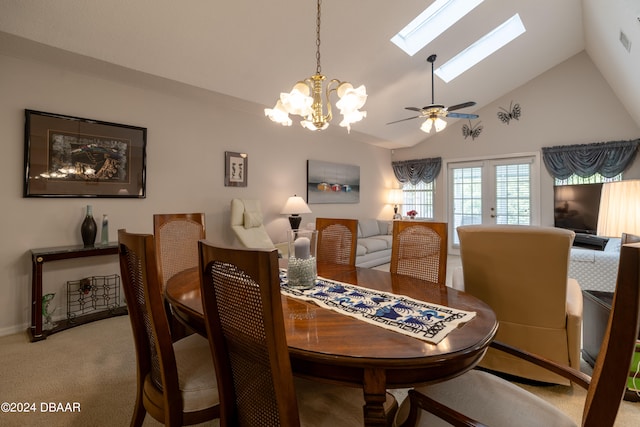 dining room with high vaulted ceiling, a skylight, carpet flooring, and ceiling fan with notable chandelier