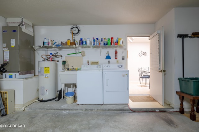 laundry area featuring water heater, heating unit, and washing machine and clothes dryer