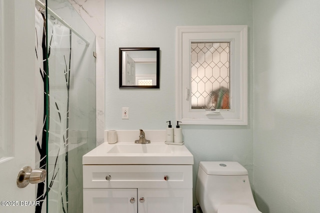 bathroom featuring toilet, vanity, and curtained shower