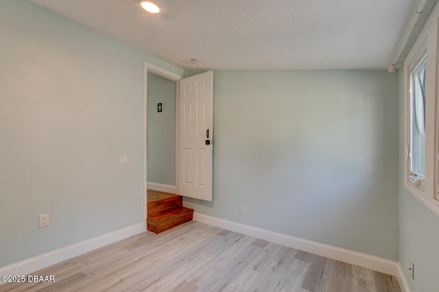 unfurnished room featuring baseboards and light wood-style floors