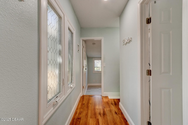 hallway with wood finished floors and baseboards