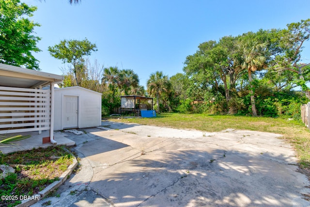 view of yard featuring a patio area, an outbuilding, and a shed