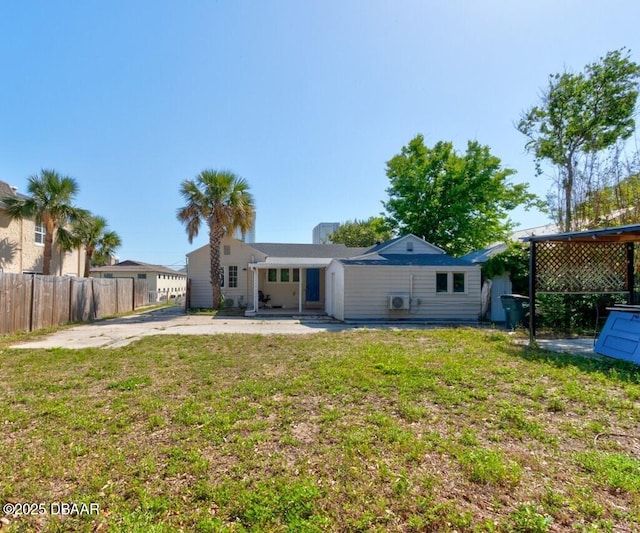 rear view of house featuring fence, a yard, and a patio