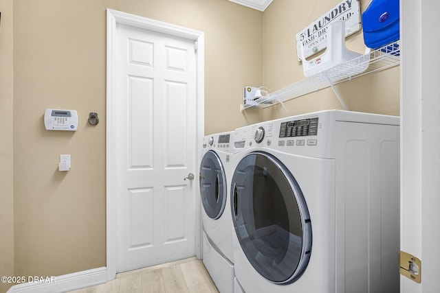 clothes washing area featuring laundry area, independent washer and dryer, and light wood-style flooring