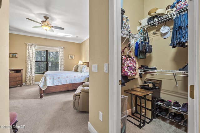 carpeted bedroom with ornamental molding, baseboards, and a ceiling fan