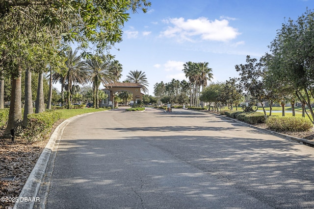 view of street with curbs and a gated entry