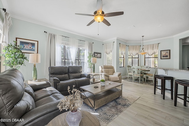 living area with light wood-style floors, visible vents, ornamental molding, and a ceiling fan