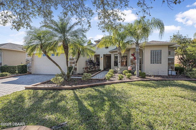 view of front of home featuring decorative driveway, stucco siding, an attached garage, stone siding, and a front lawn