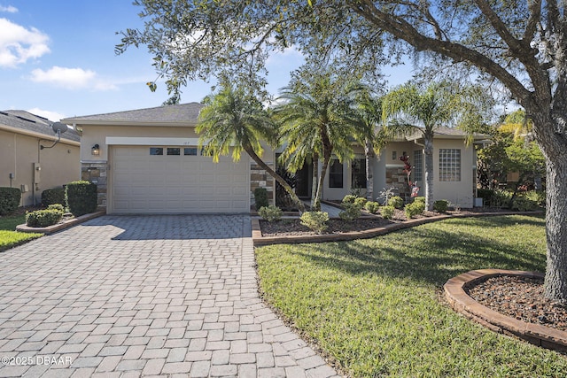 ranch-style house with stone siding, a front yard, decorative driveway, and stucco siding