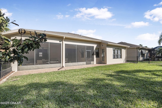 rear view of property featuring a yard, fence, a sunroom, and stucco siding