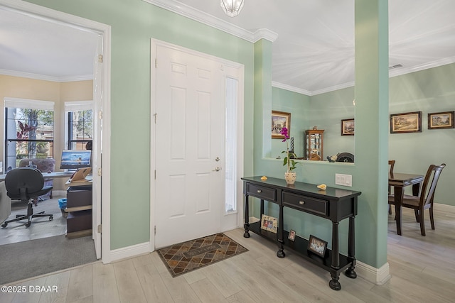 foyer entrance featuring crown molding, baseboards, and wood finished floors