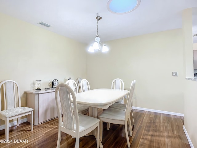 dining space with a notable chandelier and dark hardwood / wood-style floors