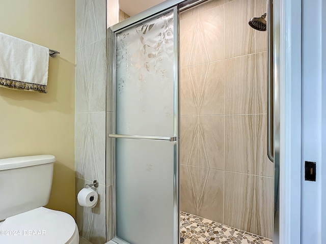 bathroom featuring toilet and an enclosed shower