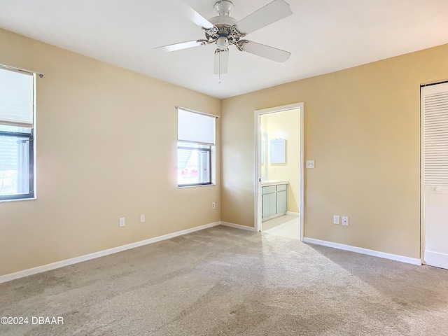 empty room featuring light colored carpet, a healthy amount of sunlight, and ceiling fan