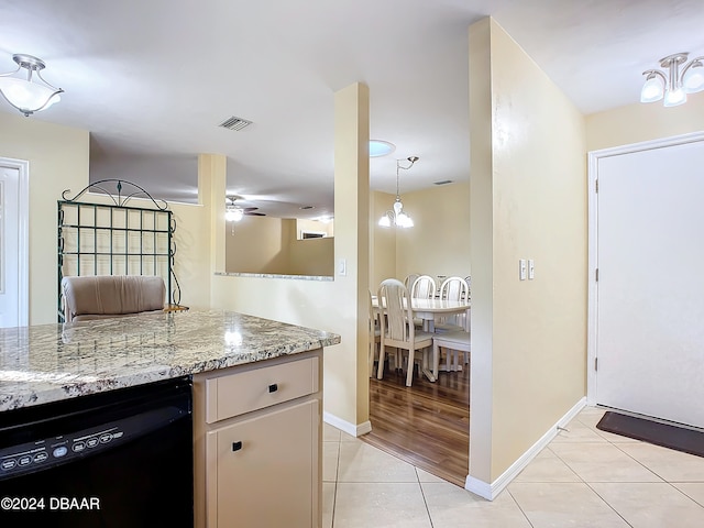 kitchen featuring dishwasher, light stone countertops, light tile patterned flooring, and ceiling fan with notable chandelier