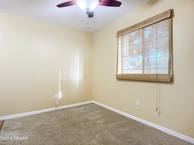 carpeted spare room with ceiling fan