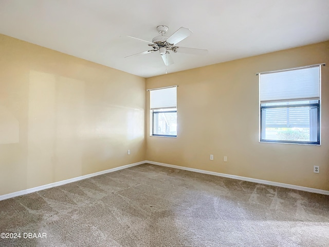 carpeted empty room featuring a wealth of natural light and ceiling fan