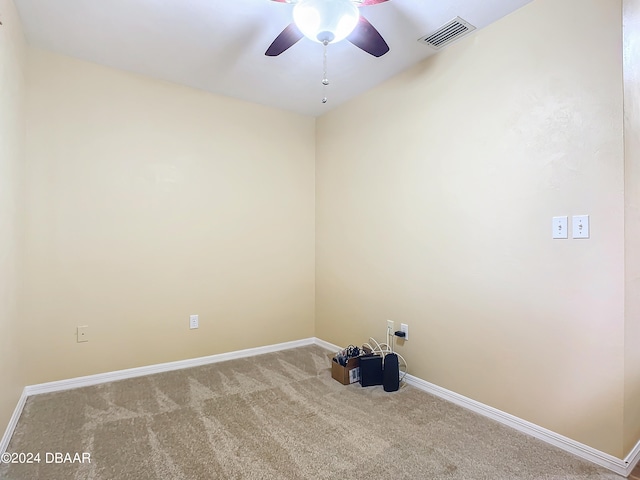 carpeted spare room with ceiling fan