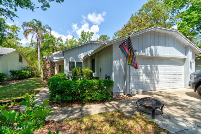view of front of property featuring a garage, a fire pit, and concrete driveway